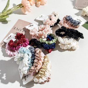 Macro detail of assorted colorful satin hair scrunchies with smooth glossy silk texture