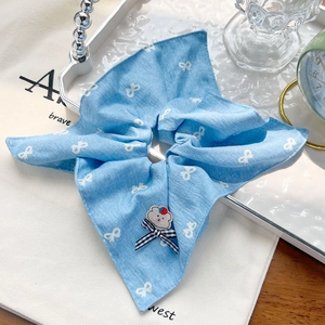 Détail du chouchou à carreaux bleu clair avec dentelle et accessoire d'ours mignon