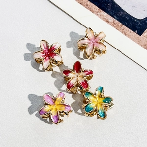 Detail view of five metal flower claw clips with gradient enamel finish on white background