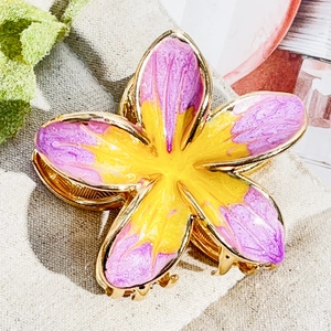 Detail of metal plumeria hair claw clip with purple petals and yellow center