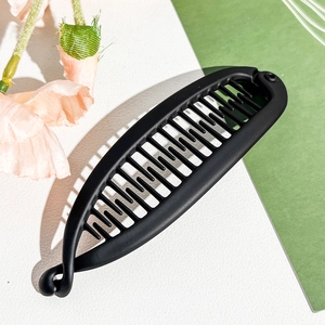 Close-up of matte black banana hair clip with dense inner teeth for ponytails
