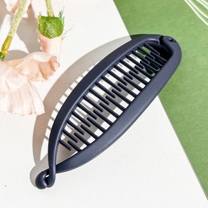 Detail view of the matte dark blue banana hair clip with interlocking comb teeth design