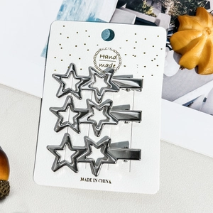 Détail de trois pinces à cheveux en forme d'étoile argentée sur carte cadeau