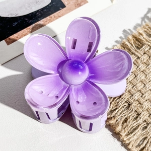 Détail macro de la pince à cheveux frangipanier violette montrant les pétales et le ressort