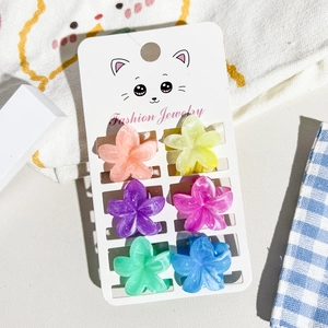 Set of six colorful flower-shaped mini hair claws on a fashion jewelry display card