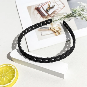 Detail of black wavy hairband with non-slip teeth and matte finish on fashion background