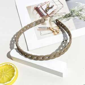 Detail of matte dark brown wavy headband showing anti-slip inner teeth and chain texture