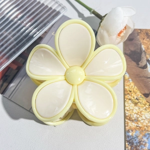 Detailed close-up of cream yellow frangipani flower hair claw clip with smooth resin finish