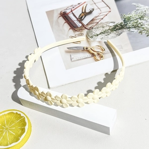 Detail view of cream yellow matte daisy hairband with a non-slip wavy floral structure