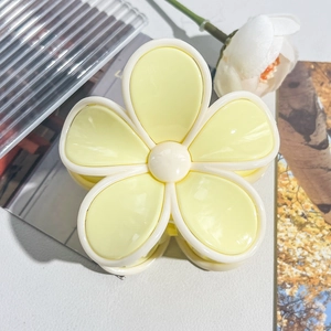 Macro shot of yellow plumeria flower hair claw clip with glossy acrylic petals