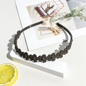 Detail showing matte brown floral resin headband with inner anti-slip teeth