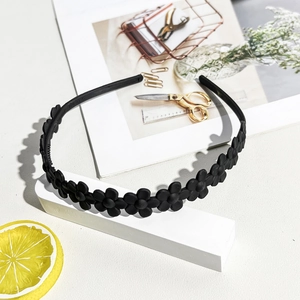 Detailed view of the black matte daisy flower headband with anti-slip inner teeth