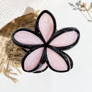 Dettaglio della pinza per capelli a fiore con petali rosa gelatina e bordi neri