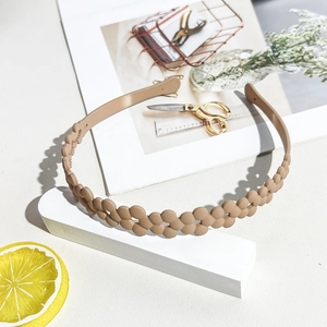 Detail view of khaki matte flower headband with non-slip teeth for stable styling