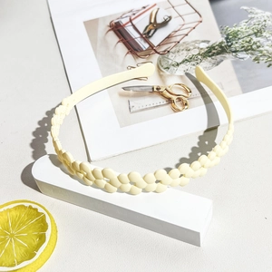 Close-up of yellow wavy matte headband on a white geometric stand with lemon decor
