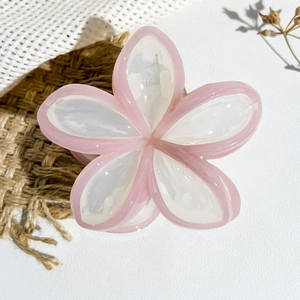 Dettaglio molletta per capelli a fiore con bordi rosa e petali in resina color crema