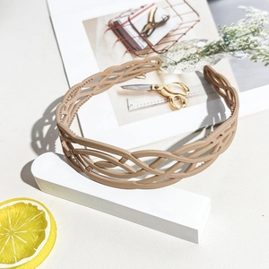 Close-up of khaki woven texture headband with non-slip teeth for secure hair styling
