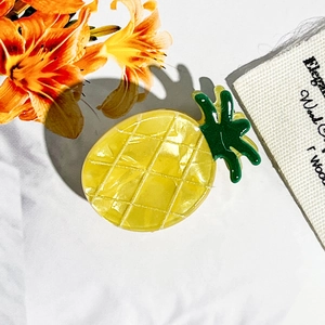 Makroaufnahme der perlmuttfarbenen Ananas-Haarklammer mit gelber Gitterstruktur