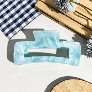 Détail de la pince à cheveux en acétate bleu clair marbré avec une finition brillante