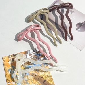 Detailed shot of bow-knot hair sticks in brown, khaki, pink, and ivory finishes