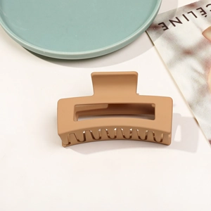 Détail d'une pince à cheveux carrée kaki mat de 8,5 cm sur fond de magazine épuré