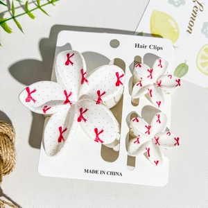 Three-piece floral hair clip set with UV printed red dots and ribbons on white resin