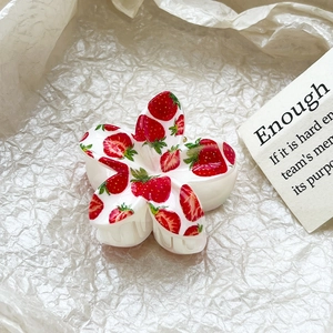Detail view of flower-shaped hair claw with strawberry prints and cream resin finish
