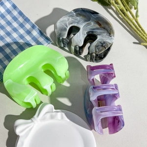 Détails des pinces à cheveux en forme de M avec motif marbré vert, gris et violet