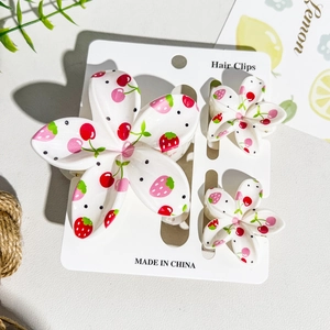 Detailed set of floral hair clips with strawberry and cherry patterns on white resin