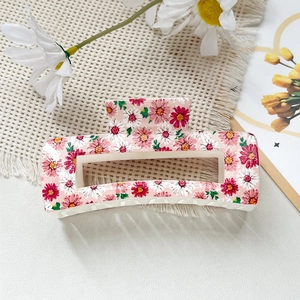 Détail d'une pince à cheveux rectangulaire avec motifs floraux de marguerites roses polies