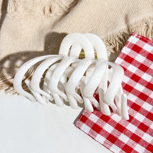 Detail of white marble acetate hair claw clip with golden metal spring for thick hair