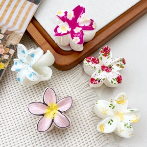 Detail showing assorted UV printed plumeria hair claws in floral and fruit patterns