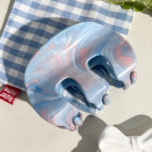 Détail de la pince à cheveux en acétate marbré bleu et rose de forme en M unique