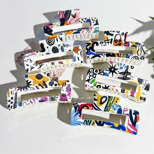 Détail de six pinces à cheveux carrées avec motifs graffiti abstraits colorés sur base blanche