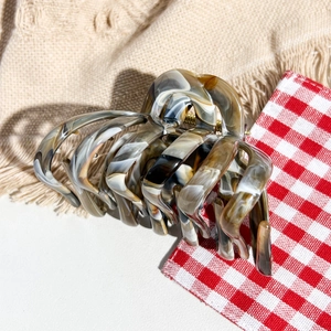 Detail showing the elegant marble pattern texture on a large claw clip with metal spring