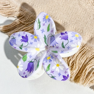 Detailed top view of a lavender frangipani hair claw clip with delicate daisy and lily patterns