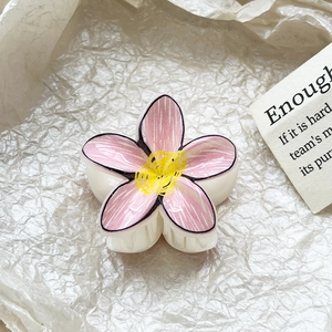 Close-up detail of a pink plumeria flower hair claw with hand-drawn style texture