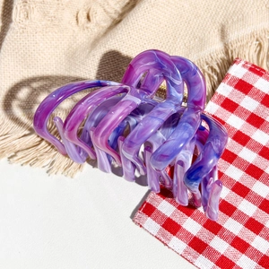 Detailed view of large marble texture hair claw clip with purple and blue resin patterns