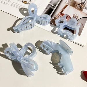 Detailed macro view of light blue acetate hair claws with elegant marble patterns