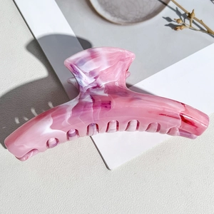 Detail of large pink and white marble textured hair claw clip with acetate finish