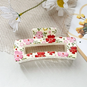 Détail d'une pince à cheveux rectangulaire crème avec motifs floraux imprimés en UV
