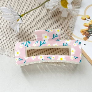 Détail de la pince à cheveux carrée rose avec imprimé marguerites et motif floral