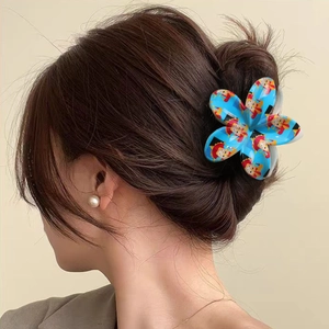 Floral hair claw clip with blue anime character pattern shown on a female hairstyle