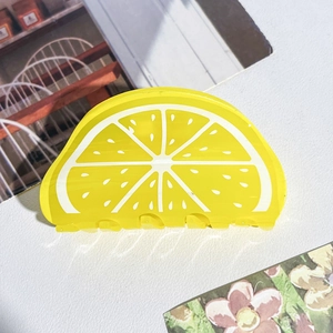 Gros plan sur la pince à cheveux en acrylique en forme de tranche de citron jaune