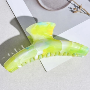 Detail view of large marble texture hair claw clip with vibrant green and blue gradient finish