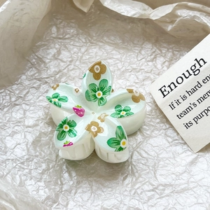 Detailed macro view of plumeria hair claw clip with floral patterns and strawberry print