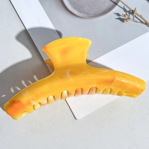 Close-up of amber marble hair claw clip with glossy finish and smooth teeth