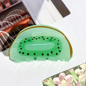 Vue macro de la pince à cheveux en acrylique motif kiwi vert avec détails