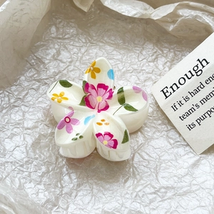 Macro detail of Frangipani hair claw with custom floral print on white acetate petals