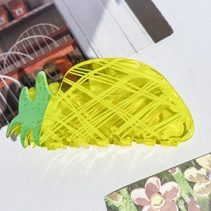 Détail macro d'une pince à cheveux jaune en forme d'ananas avec texture réaliste